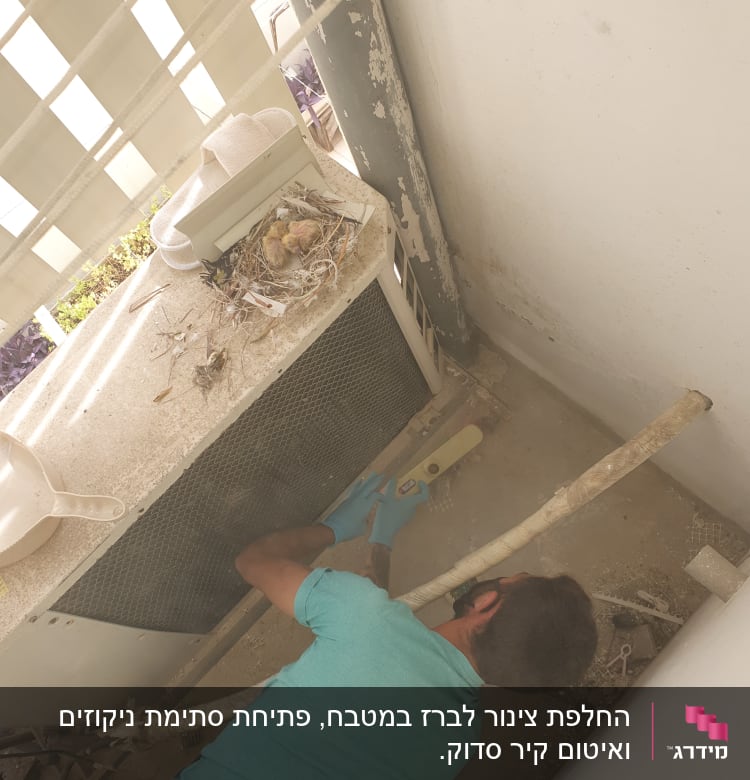 אדם עם כפפות מתקין צינור ליד מזגן